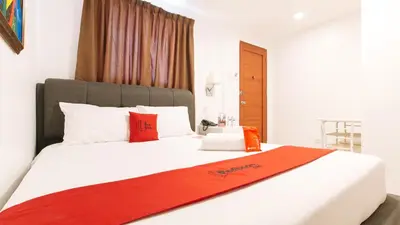 a bedroom with a large white bed with red pillows at RedDoorz near Mercado del Lago in Manila