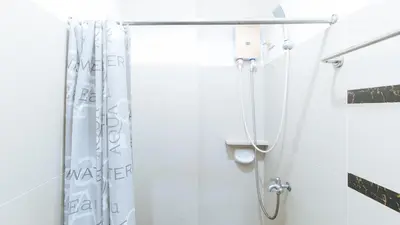 a shower in a bathroom with a shower curtain at RedDoorz at CAA Road Las Pinas in Manila