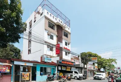 a building on a busy city street with cars and motorcycles at RedDoorz at CAA Road Las Pinas in Manila