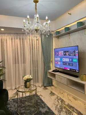 a living room with a chandelier and a tv at City View at MAKATI Prime Luxury in Manila