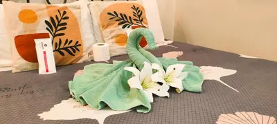 a towel on a bed with flowers on it at Centropolis King Bed Deluxe in Manila