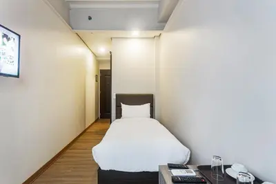 a small room with a bed and a desk at Airo Hotel Manila in Manila