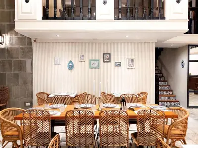 a dining room with a wooden table and chairs at Airo Hotel Manila in Manila