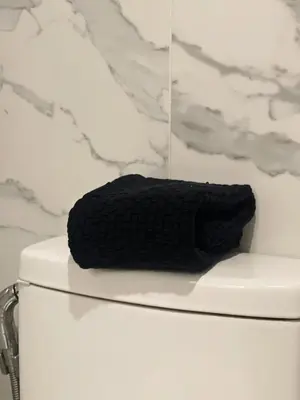 a black towel sitting on top of a toilet at Airo Hotel Manila in Manila