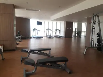 a gym with several tread machines in a large room at Andy's Place One Eastwood Tower 1 in Manila