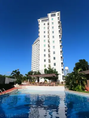 a tall building with a large pool in front of it at Choco Condotel- Anuva Prime 1 Couple Suite Lakeview in Manila