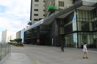 a man on a bike in front of a building at A2J Luxury BGC Balcony Suite Near SM AURA Taguig in Manila