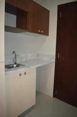 a kitchen with white cabinets and a sink at G Square Residences in Manila