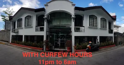 a white building with the words turn to gain at Grand Traveler Suite Inc in Manila