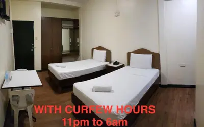 a hotel room with two beds and a sign that reads with curry hours at Grand Traveler Suite Inc in Manila