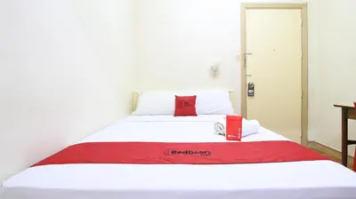 a white bed with a red blanket on it at RedDoorz Plus @ Chinatown Binondo in Manila