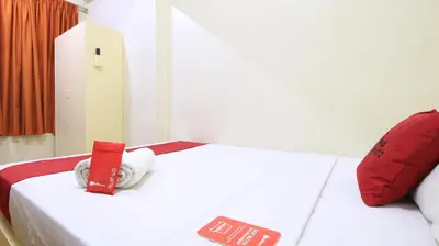 a bedroom with two beds with red and white sheets at RedDoorz Plus @ Chinatown Binondo in Manila