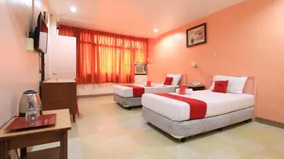 a hotel room with two beds and a desk at RedDoorz Plus @ Chinatown Binondo in Manila