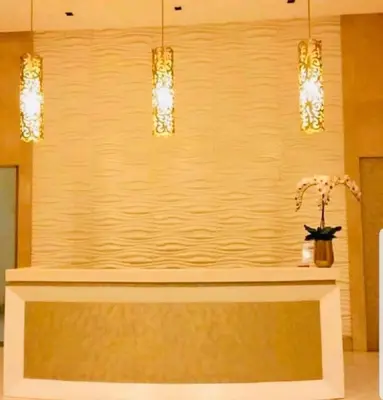 a lobby with a reception counter with three lights at Favila Condotel Unit-150 Newport Boulevard near Airport Terminal 3 and all other Airport in Manila