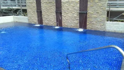 a swimming pool with blue water in a building at Favila Condotel Unit-150 Newport Boulevard near Airport Terminal 3 and all other Airport in Manila