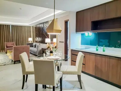 a kitchen and living room with a table and chairs at The Excelsior Hotel Las Piñas in Manila
