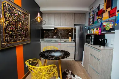 a kitchen with a table and yellow chairs in a kitchen at UNWND Flats in Manila