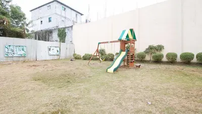 a playground with a slide in a yard at RedDoorz Plus at Alpina Heights Paranaque in Manila