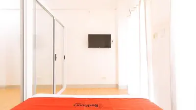 a room with a bed and a tv on a wall at RedDoorz Plus at Alpina Heights Paranaque in Manila