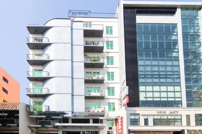 a tall white building with balconies on it at Orange Nest Hotel in Manila