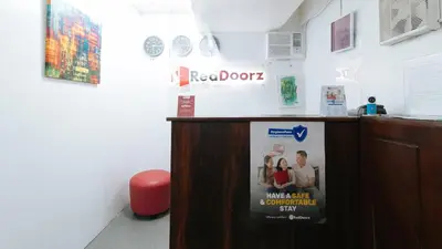 a reception desk with a poster on the wall at RedDoorz near Pasay Rotonda in Manila