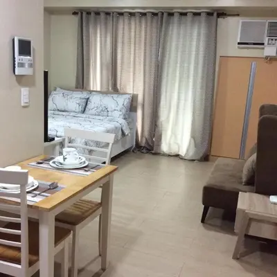 a living room with a bed and a table and a dining room at NAIA Terminal 3 Condotel by Ann in Manila