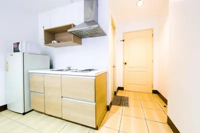 a kitchen with a sink and a refrigerator at OYO 769 Poblacion Suites Polaris in Manila