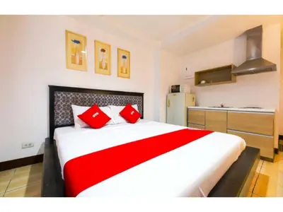 a bedroom with a large bed with red pillows at OYO 769 Poblacion Suites Polaris in Manila