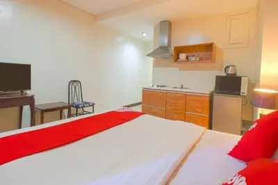 a bedroom with a large bed and a kitchen at OYO 769 Poblacion Suites Polaris in Manila