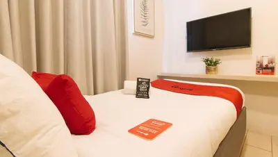 a hotel room with a bed and a flat screen tv at RedDoorz Plus at La Belle Residences Makati City in Manila