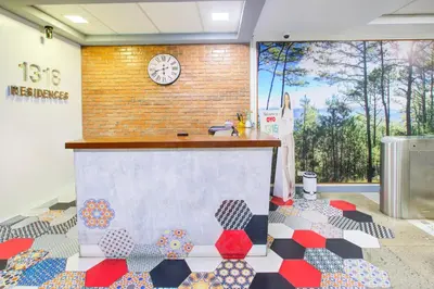 a room with a counter with a clock on the wall at Collection O Metro Manila near University Belt formerly 1318 Residences in Manila