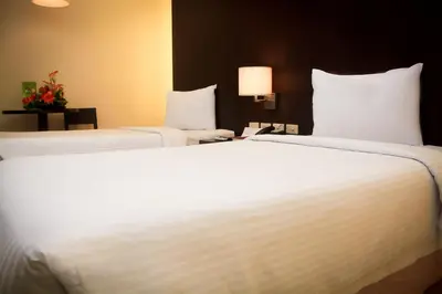 two large white beds in a hotel room at CityState Tower Hotel in Manila