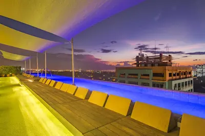 a swimming pool on the roof of a building at night at Azumi Boutique Hotel in Manila