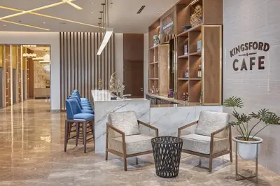 a lobby with chairs and a counter with a cafe at Kingsford Hotel Manila Bay in Manila