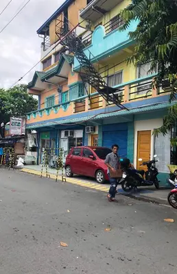 a person standing in the street in front of a building at Belen Favila Transient rooms near Airport Terminal 3 in Manila