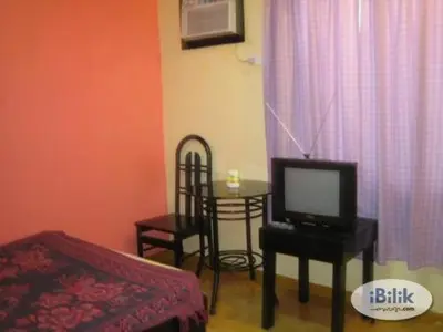 a living room with a tv and a table with a chair at Belen Favila Transient rooms near Airport Terminal 3 in Manila