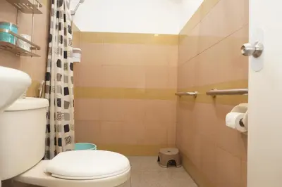 a small bathroom with a toilet and a shower at Mint Homes in CEV Mansion in Manila
