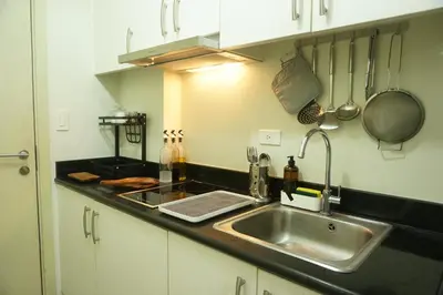 a kitchen with a sink and a counter top at Mint Homes in Jazz Residences Tower B in Manila
