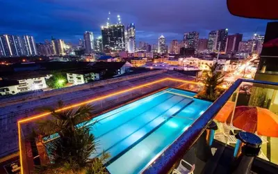 a swimming pool on top of a building with a city skyline at Jade Hotel and Suites in Manila