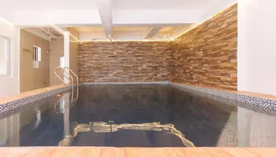 a swimming pool in a room with a brick wall at RedDoorz Plus near Tambo Paranaque in Manila
