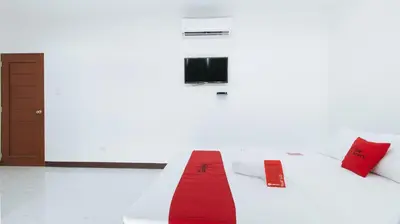 a room with a white bed with a red blanket at RedDoorz at Good 101 Paranaque in Manila