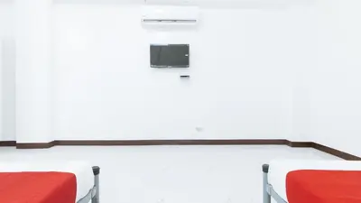 a room with two beds and a tv on a wall at RedDoorz at Good 101 Paranaque in Manila