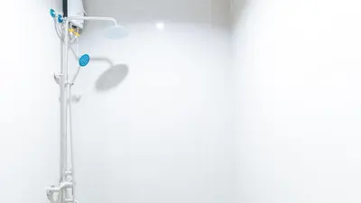 a shower in a bathroom with a white wall at RedDoorz at Good 101 Paranaque in Manila