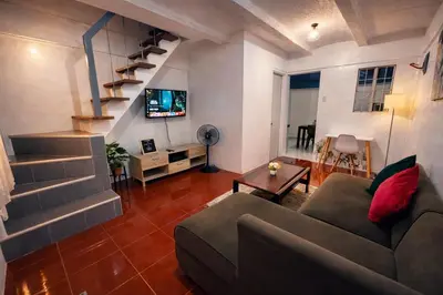 a living room with a couch and a tv at Transient Home at Tierra Vista near SM Dasma with Wifi and Netflix in Mabatang