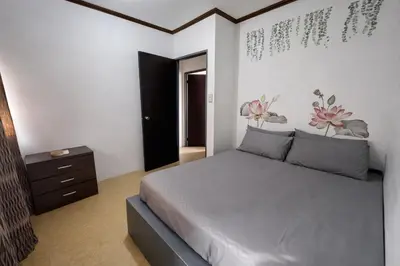 a bedroom with a bed with flowers on the wall at Transient Home at Tierra Vista near SM Dasma with Wifi and Netflix in Mabatang