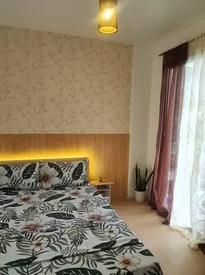 a bedroom with a bed with a floral comforter at Muji-inspired Home, 2-BR Bungalow Home Trece Martires in Trece Martires
