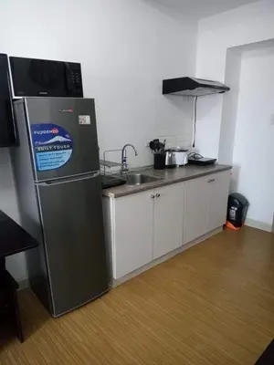 a kitchen with a refrigerator and a sink at Taguig City Grace Residences with small balcony in Manila