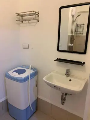 a bathroom with a trash can and a sink at Taguig City Grace Residences with small balcony in Manila
