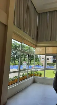 a large room with windows and potted plants at Amaia Steps Nuvali fully furnished unit with swimming pool view near Carmelray Pitland in Calamba
