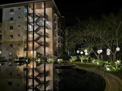 a night view of a building with lights at Amaia Steps Nuvali fully furnished unit with swimming pool view near Carmelray Pitland in Calamba
